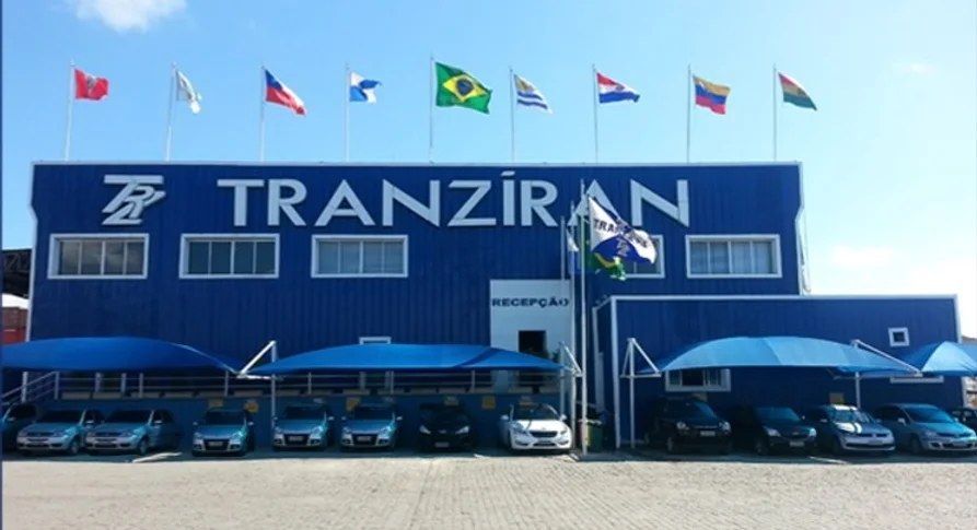 Fachada da sede da Tranziran com bandeiras e logotipo da empresa