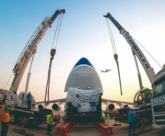 Dois guindastes içando a fuselagem de uma aeronave