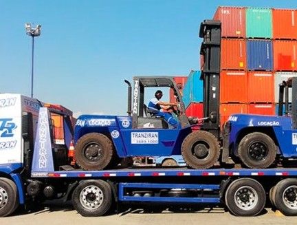 Carreta plataforma transportando empilhadeira no terminal de contêineres