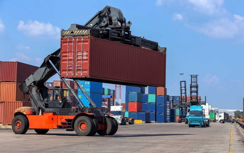 Equipamento de movimentação erguendo um contêiner no pátio da Tranziran